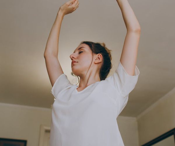 Person stretching peacefully in a bright, modern living room.